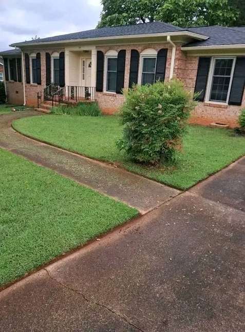 Freshly mowed lawn in front of brick house — by Kellyscappers Central